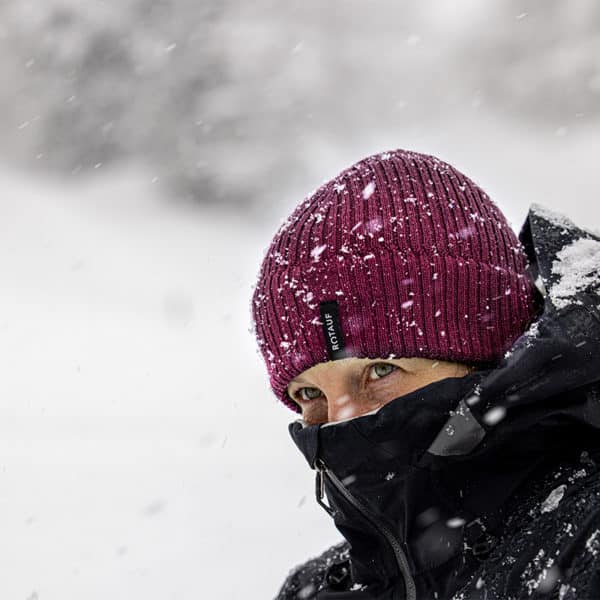 Frau im Schneegestöber mit Rotauf Merino Beanie in bordeaux