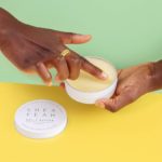 Finger nimmt etwas Belly Butter aus der Dose