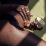 Frau reibt sich Belly Butter auf den schwangeren Bauch