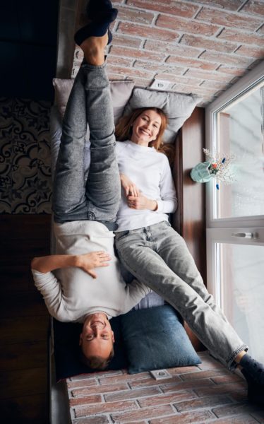 Paar liegt auf Fensterbank und lacht