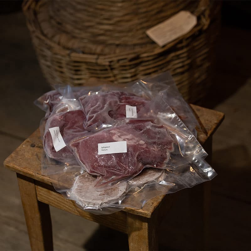 Fleischmischpaket zum online kaufen in vakuumierten Stücken auf Holzhocker platziert