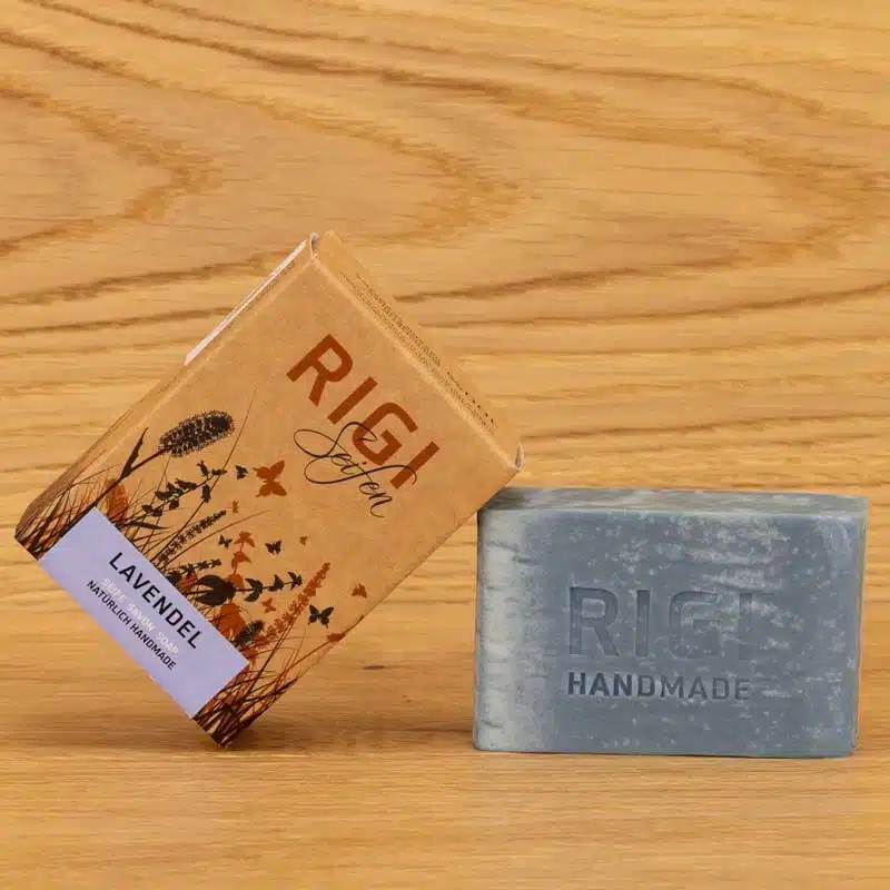 Verpackung der Rigi Seifen in der Variante Lavendel. Die Verpackung ist an die blaue Seife angelehnt. Auf der Seife ist RIGI HANDMADE eingeprägt.