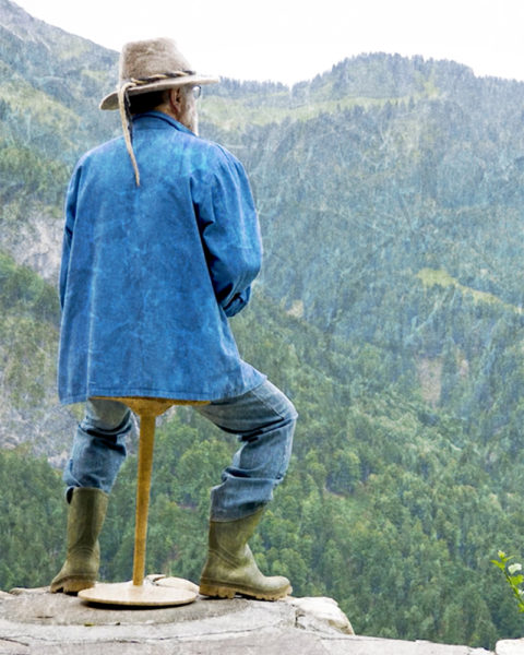 Mann sitzt auf Spurenlos Hocker und schaut auf ins Tal