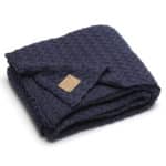 dunkelblaue Strickdecke mit Zopfmuster gefaltet