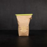 Mittlerer Tuetenhueter verschliesst eine offene Packung Maisgries