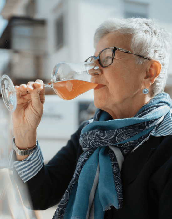 Kundin trinkt Glas Wein in der Sonne