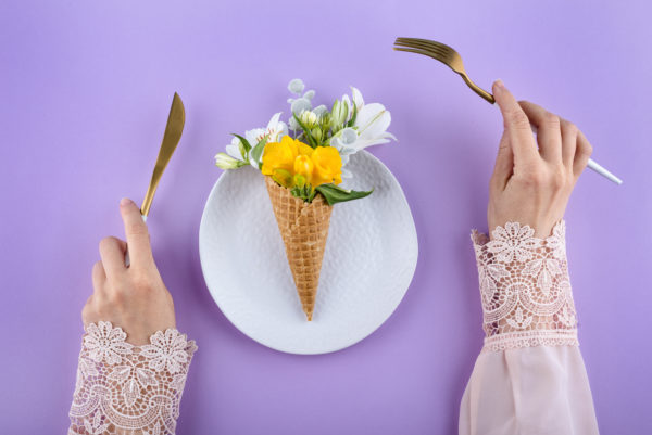 Hände und Tisch mit Blumen-Cornet